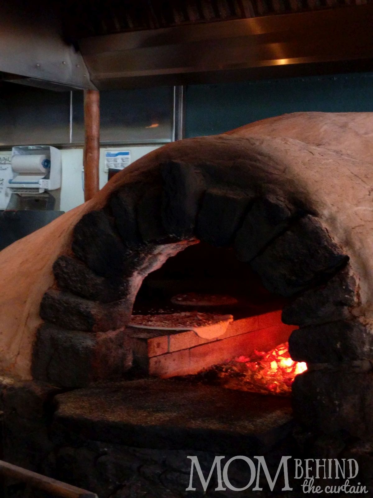 Man putting pizza in wood fired over, BeBest Pizza Maui in wood oven The Flatbread Company, Pa'ia